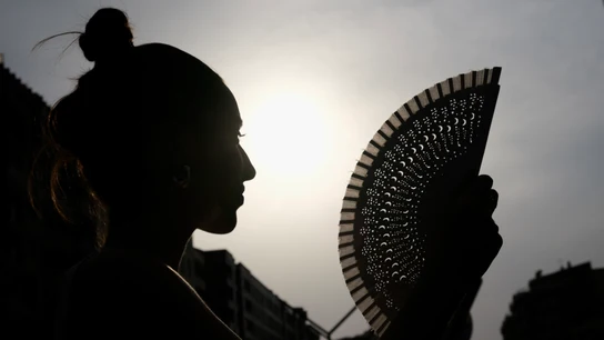 Imagen de una mujer abanicándose Imagen de una mujer abanicándose