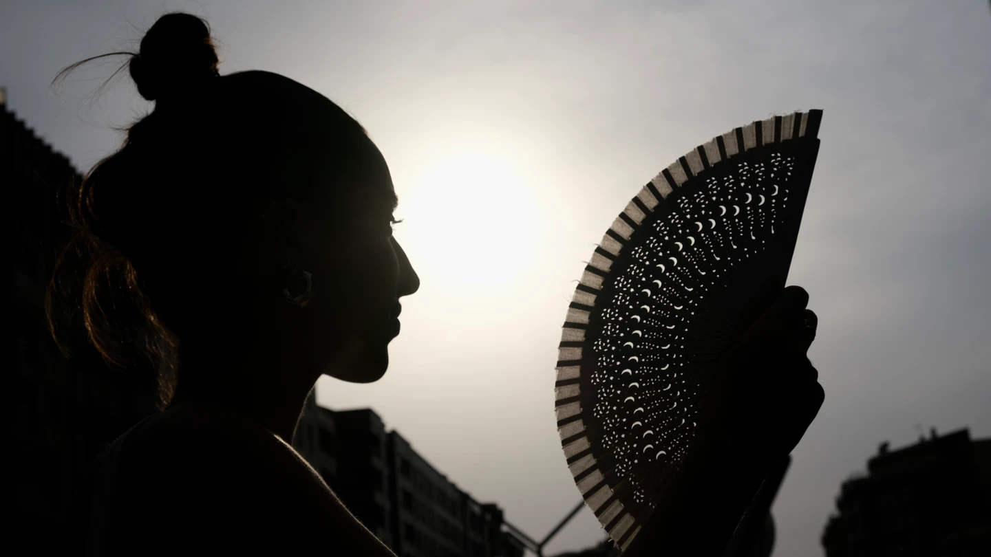 Imagen de una mujer abanicándose Imagen de una mujer abanicándose
