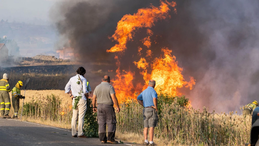 Varios vecinos observan las llamas del incendio declarado en el término municipal de Quintanilla del Coco, en Burgos