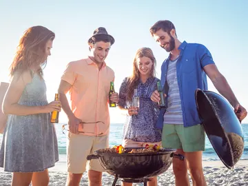 Grupo de jóvenes haciendo barbacoa en la playa Grupo de jóvenes haciendo barbacoa en la playa