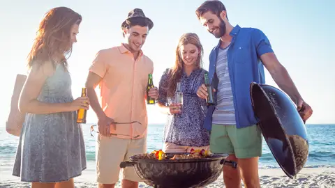 Grupo de jóvenes haciendo barbacoa en la playa Grupo de jóvenes haciendo barbacoa en la playa