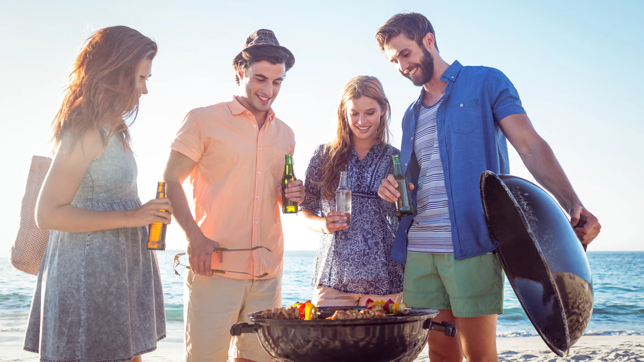 Grupo de jóvenes haciendo barbacoa en la playa Grupo de jóvenes haciendo barbacoa en la playa