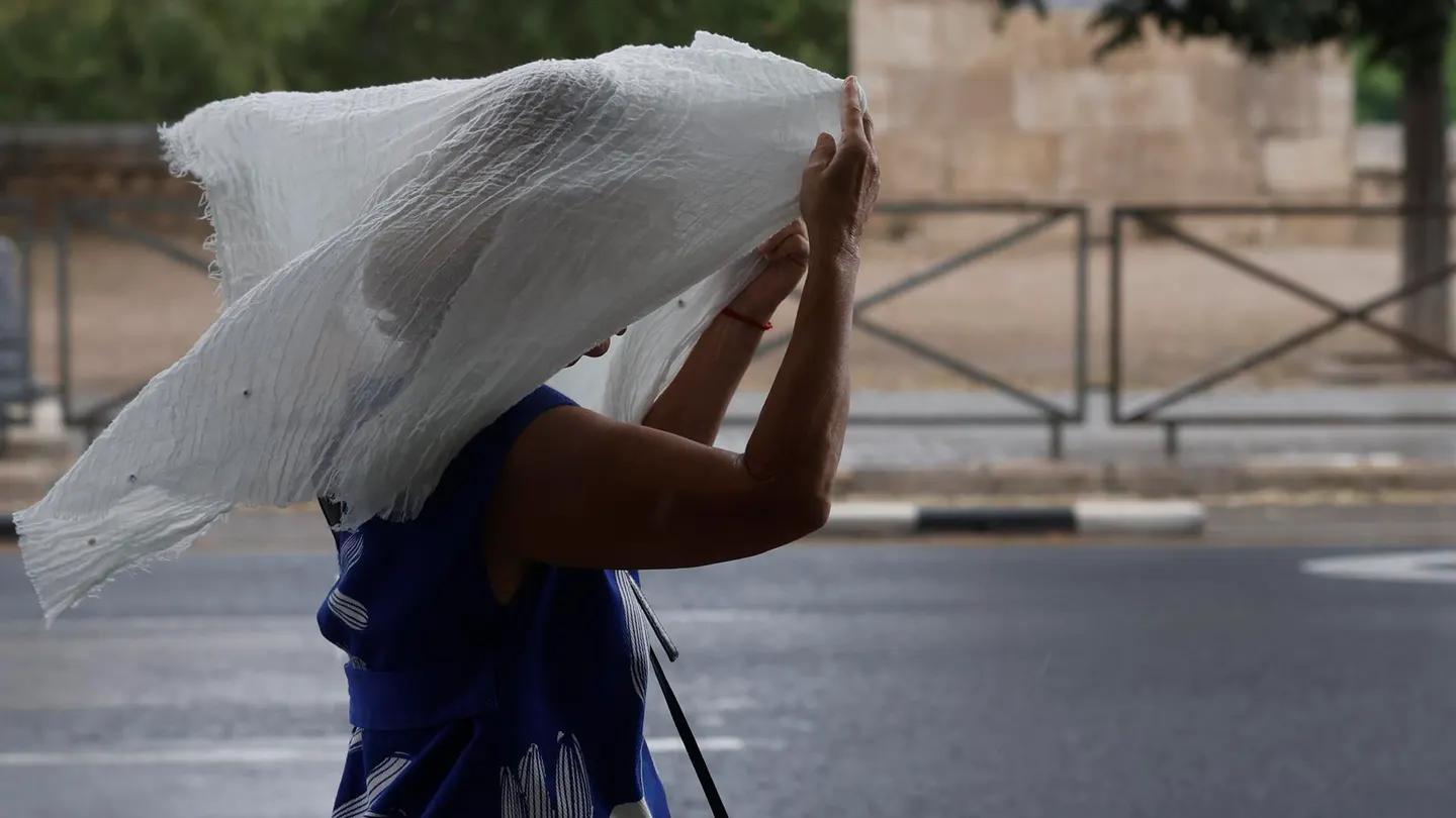 Imagen de archivo de una mujer que se protege de la lluvia durante una tormenta caída en Valencia Imagen de archivo de una mujer que se protege de la lluvia durante una tormenta caída en Valencia