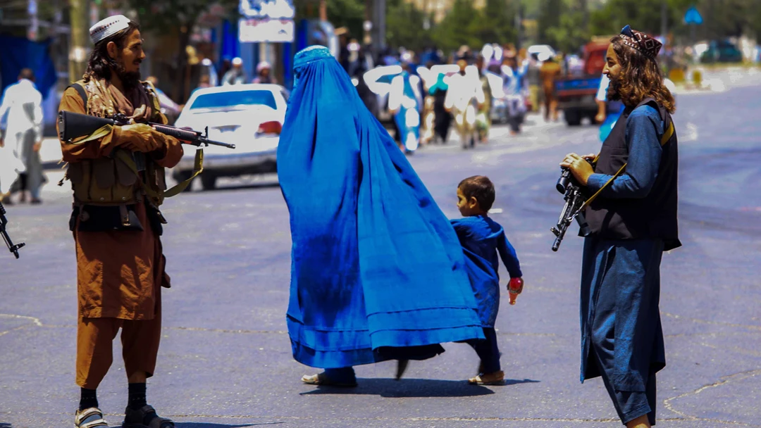 Tropas talibanes en Afganistán vigilando a una mujer con un burka (archivo)