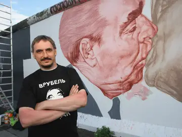El artista ruso Dmitri Vrúbel, frente al Beso del Muro de Berlín.