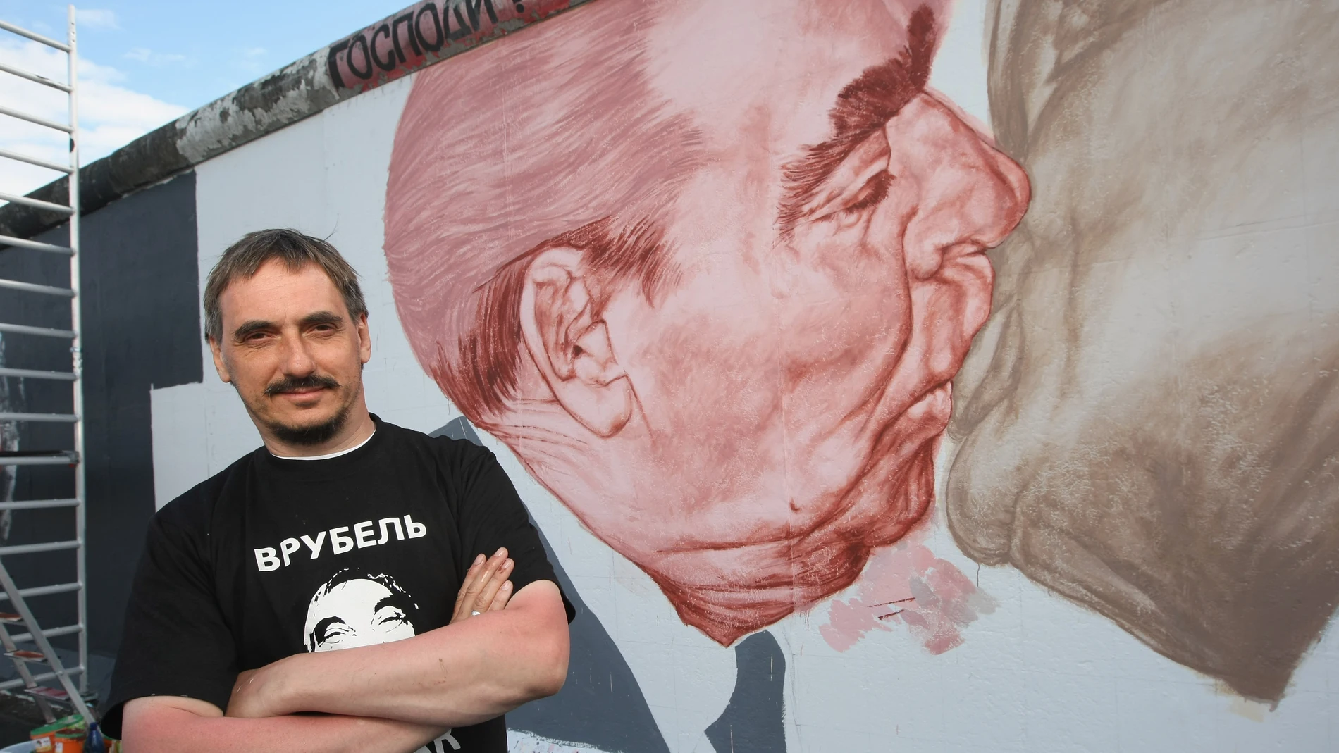 El artista ruso Dmitri Vrúbel, frente al Beso del Muro de Berlín.