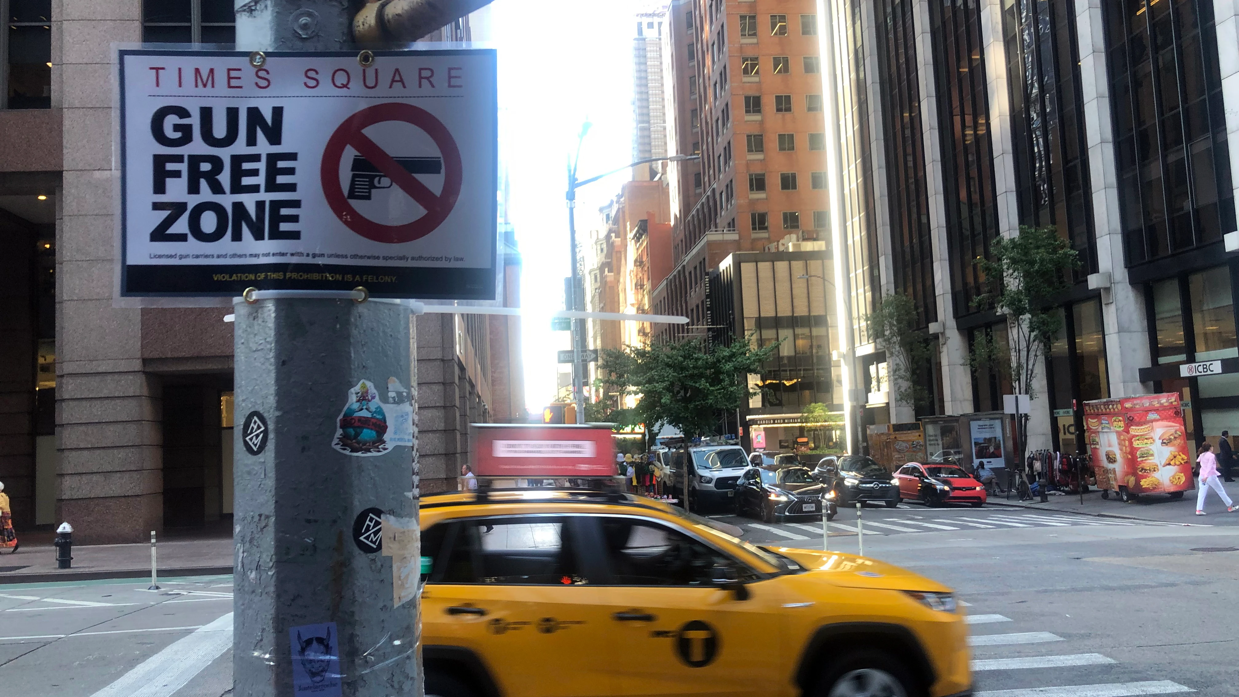 Un taxi pasa delante de un letrero con el mensaje "Times Square, zona libre de armas".