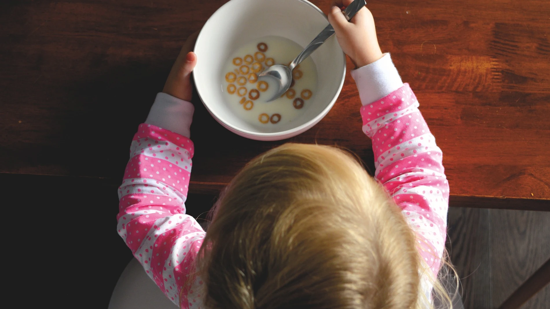 Una niña comiendo cereales. 