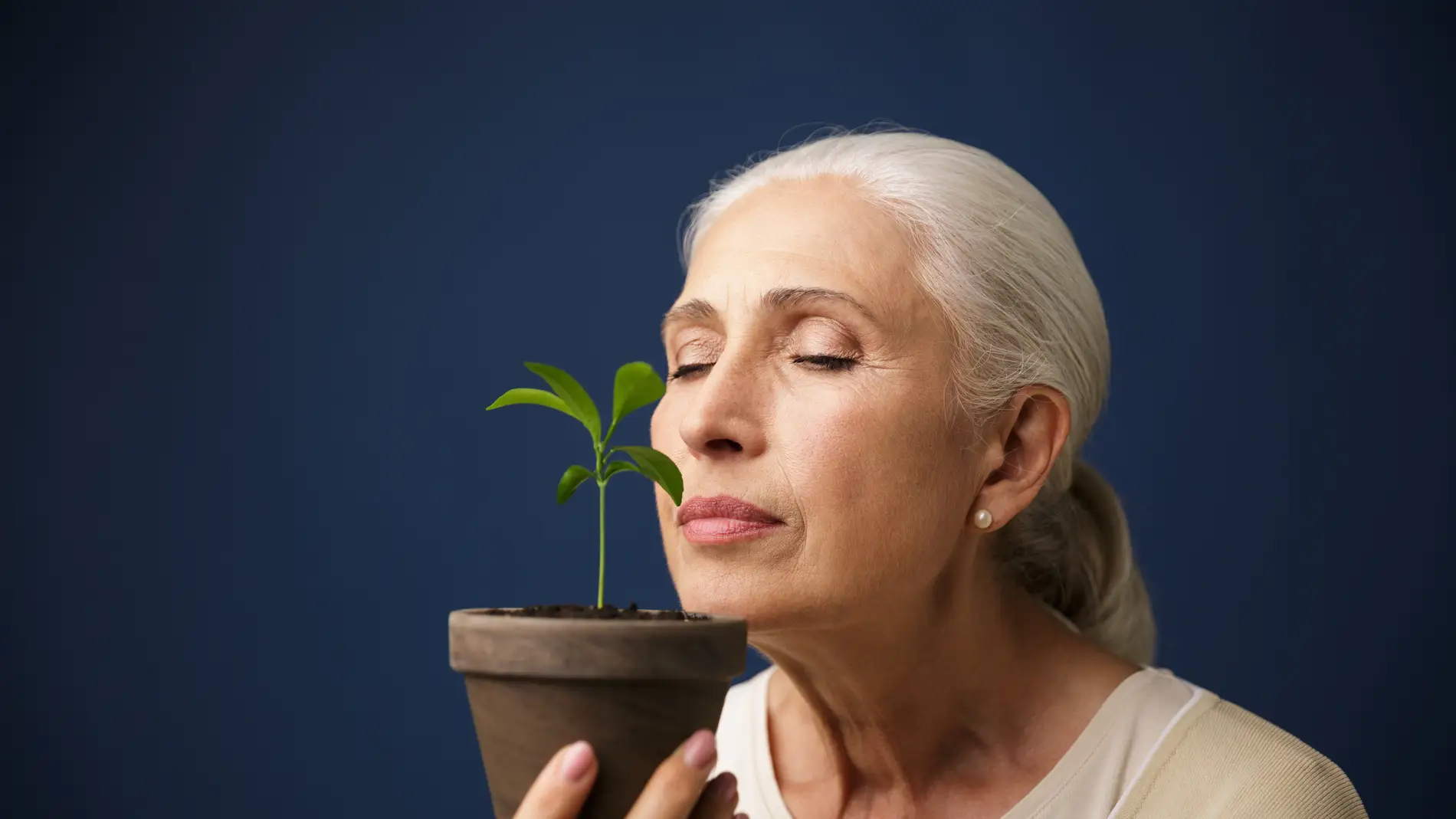 Mujer huele una planta