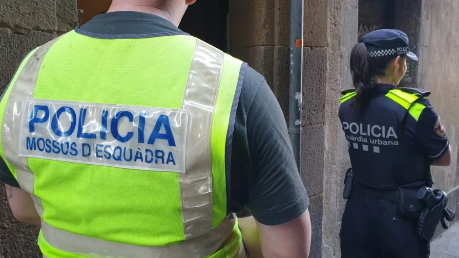 Imagen de archivo un agente de los Mossos d'Esquadra y una agente de la Guardia Urbana de Barcelona