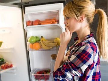 Mujer mirando la nevera abierta Mujer mirando la nevera abierta