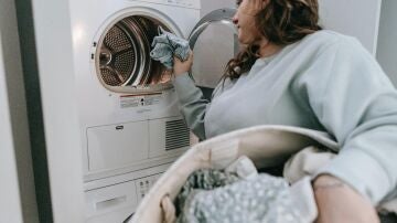 Una mujer poniendo una lavadora