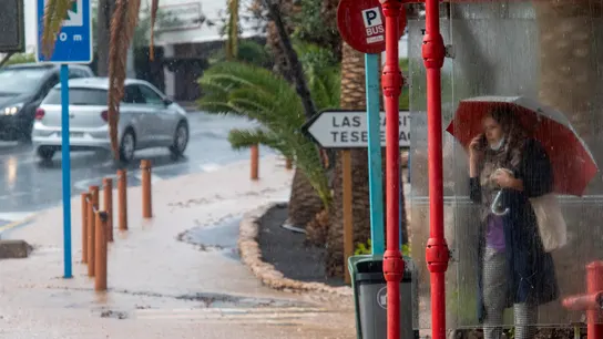 Una mujer se resguarda de la lluvia en Tuineje, Fuerteventura Una mujer se resguarda de la lluvia en Tuineje, Fuerteventura