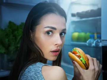 Una mujer con hambre delante de la nevera Una mujer con hambre delante de la nevera