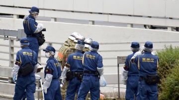 Operarios trabajan en la zona donde un hombre se ha prendido fuego en protesta por el funeral de Abe