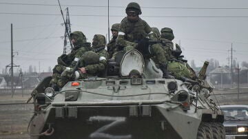 Soldados rusos al frente de un carro de combate.