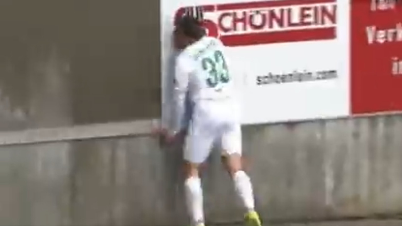 Ein Fußballspieler prallt während eines Spiels gegen eine Wand und fällt bewusstlos zu Boden Ein Fußballspieler prallt während eines Spiels gegen eine Wand und fällt bewusstlos zu Boden