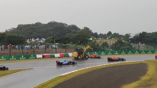 La grúa, recogiendo el coche de Sainz con el resto de monoplazas pasando muy cerca La grúa, recogiendo el coche de Sainz con el resto de monoplazas pasando muy cerca