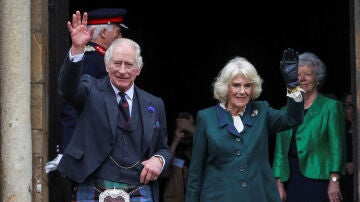 El rey Carlos III y la reina Camila saludan