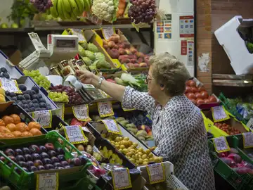 Imagen de archivo de una mujer comprando fruta en un mercado