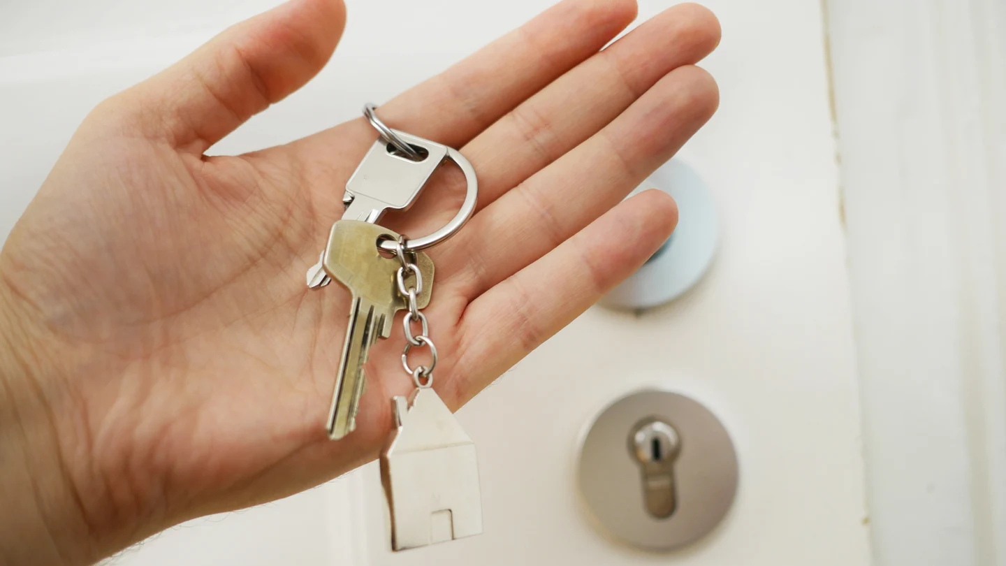 Una persona muestra las llaves de una vivienda. Qué es la tasa single y por qué penaliza a las personas solteras para comprar una casa