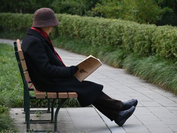 Anciano leyendo el periódico en un parque