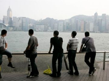 turistas observando el perfil de la ciudad de Hong Kong