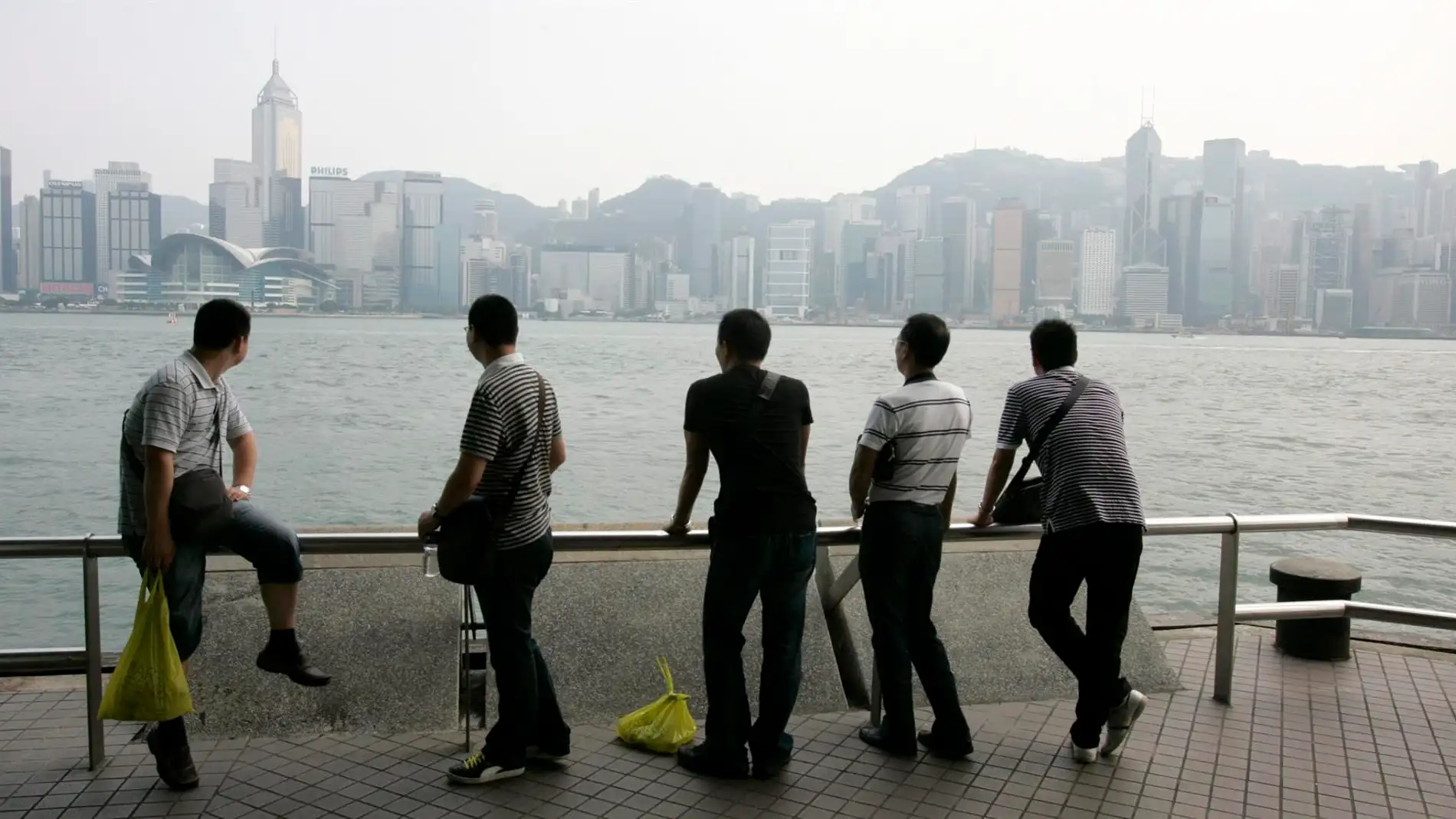 turistas observando el perfil de la ciudad de Hong Kong