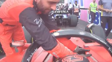 Un mecánico ayuda a Carlos Sainz a salir del Ferrari