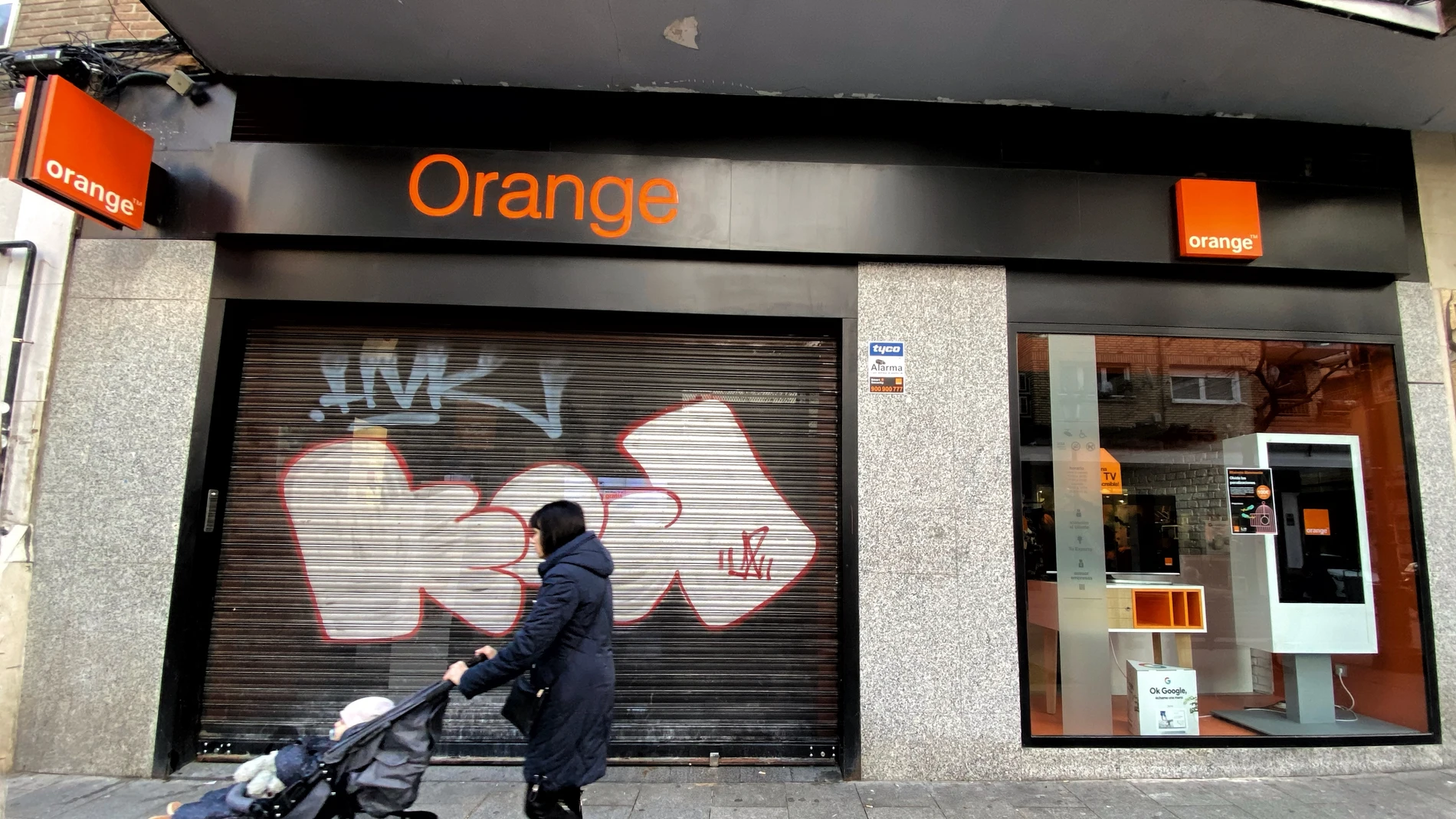 Una mujer pasea frente a una tienda de de la compañía telefónica Orange