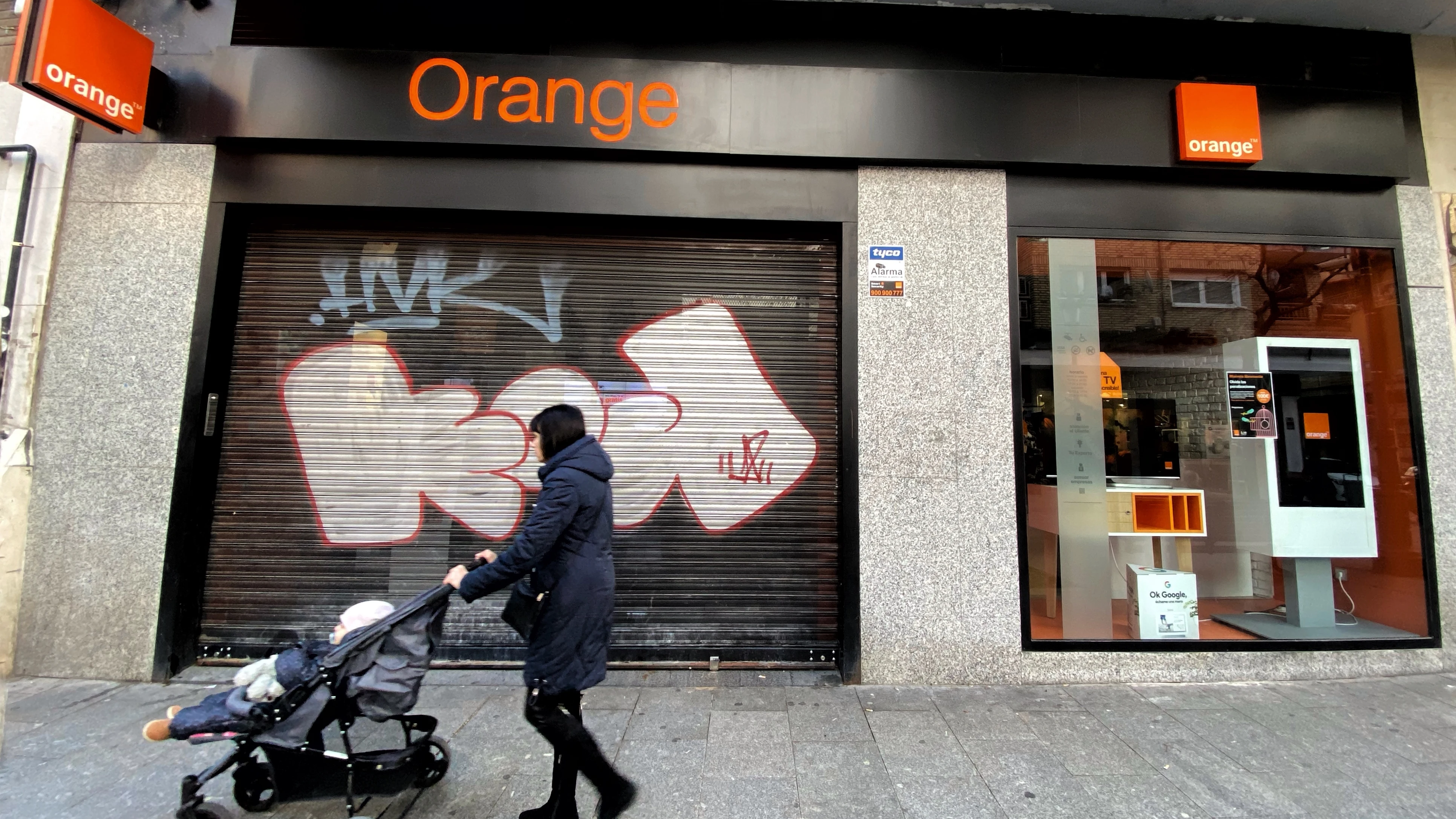 Una mujer pasea frente a una tienda de de la compañía telefónica Orange