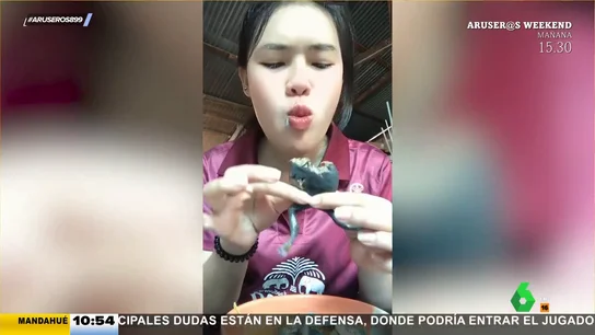 Una joven se come ante la cámara un exótico manjar: una rana hervida Una joven se come ante la cámara un exótico manjar: una rana hervida