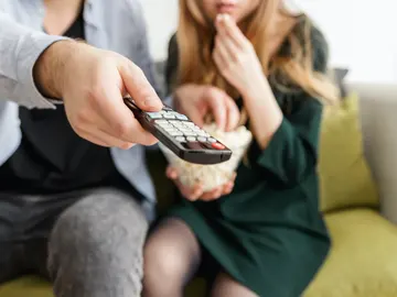Personas comiendo snacks con la televisión Personas comiendo snacks con la televisión