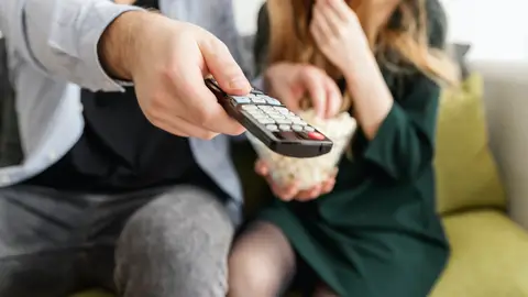 Personas comiendo snacks con la televisión Personas comiendo snacks con la televisión