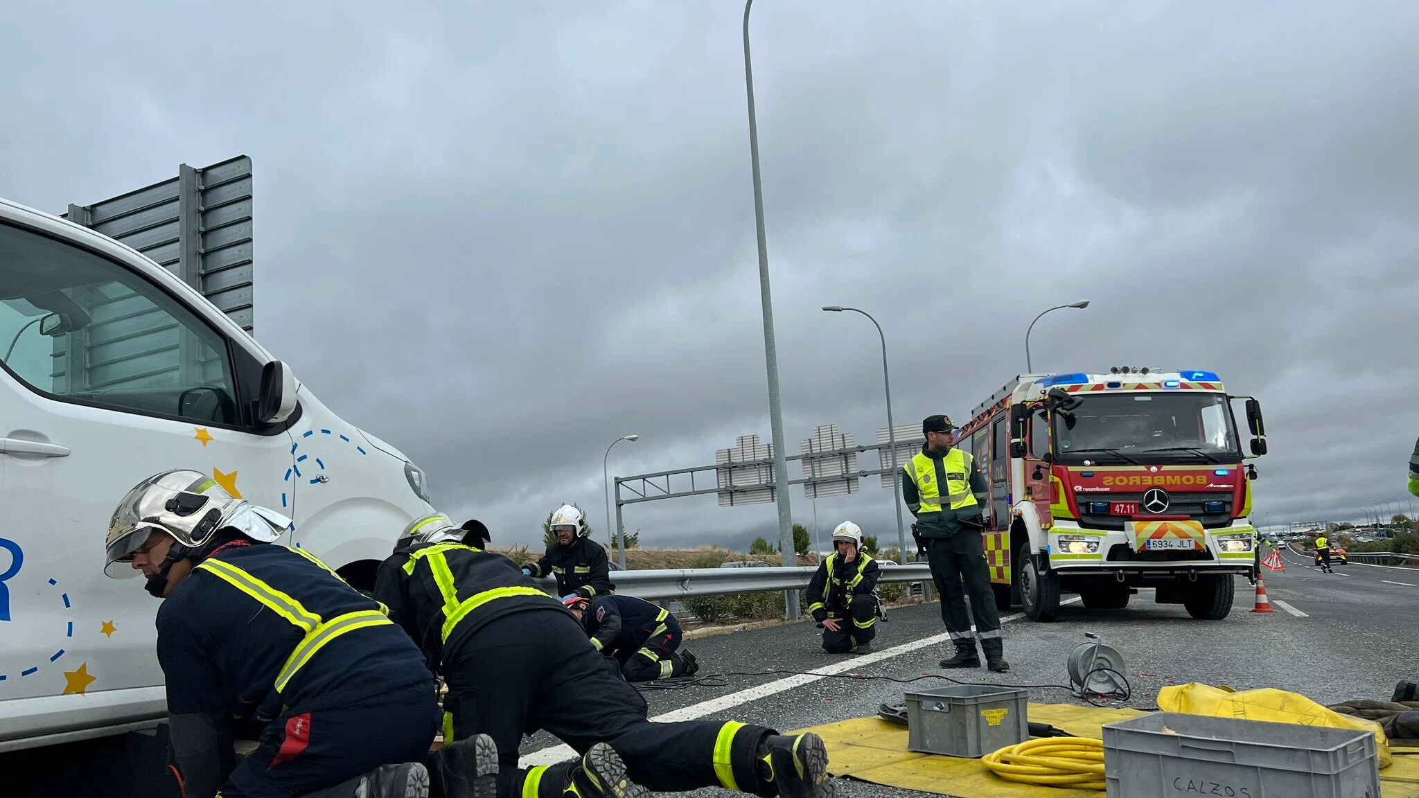 Los bomberos rescatan el cuerpo de la víctima atrapada debajo del vehículo.