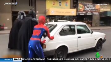 SpiderMan, Batman y Darth Vader empujan un coche por una céntrica calle de Argentina