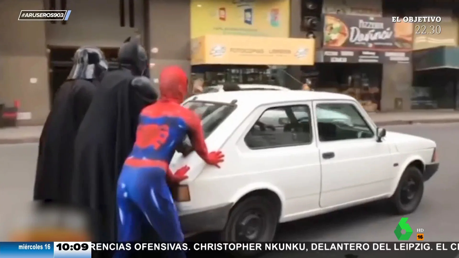 SpiderMan, Batman y Darth Vader empujan un coche por una céntrica calle de Argentina