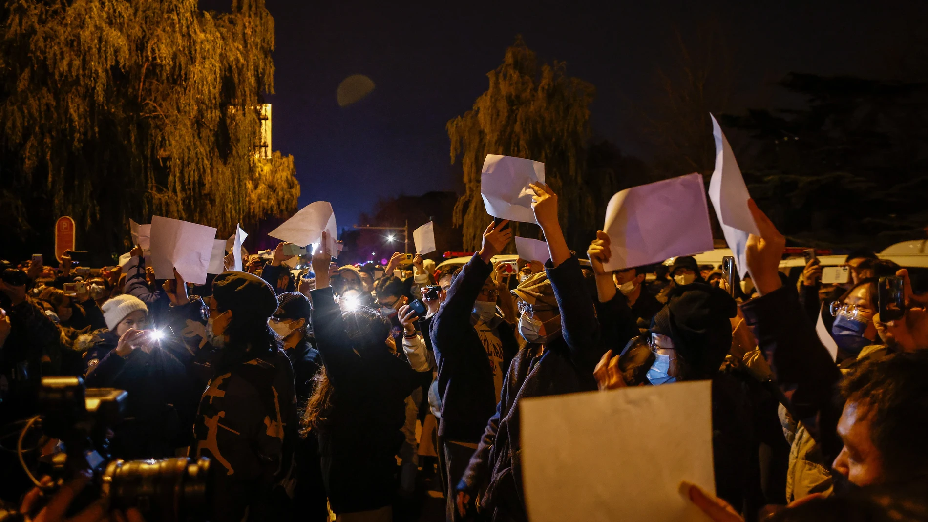 Manifestantes agitan papeles blancos en una protesta en Pekín tras un incendio en Urumqi