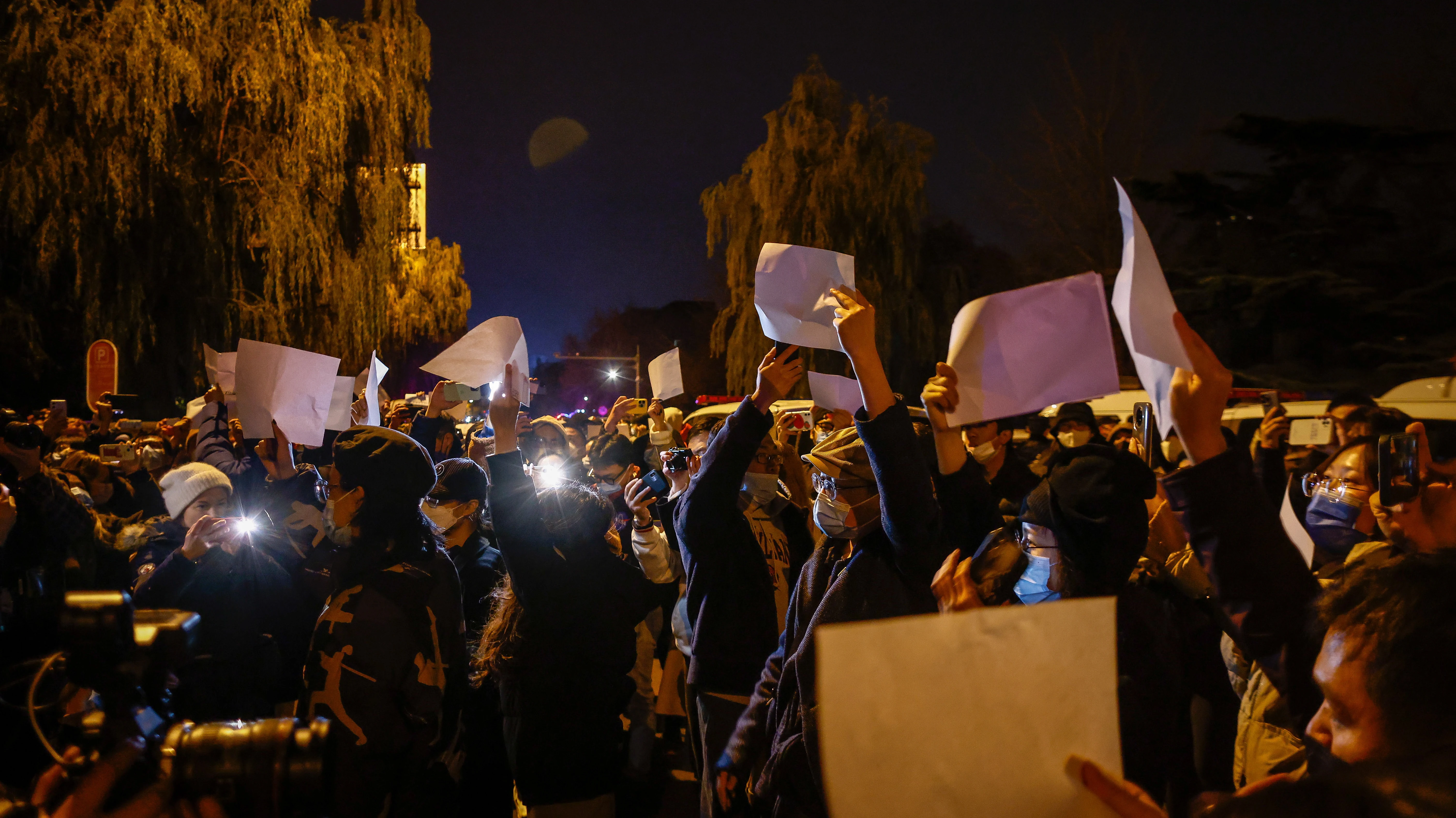 Manifestantes agitan papeles blancos en una protesta en Pekín tras un incendio en Urumqi