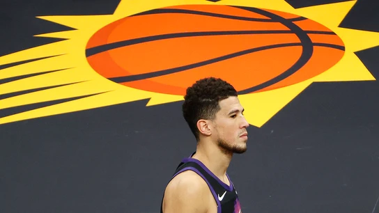 Devin Booker, con el logo de los Phoenix Suns de fondo Devin Booker, con el logo de los Phoenix Suns de fondo