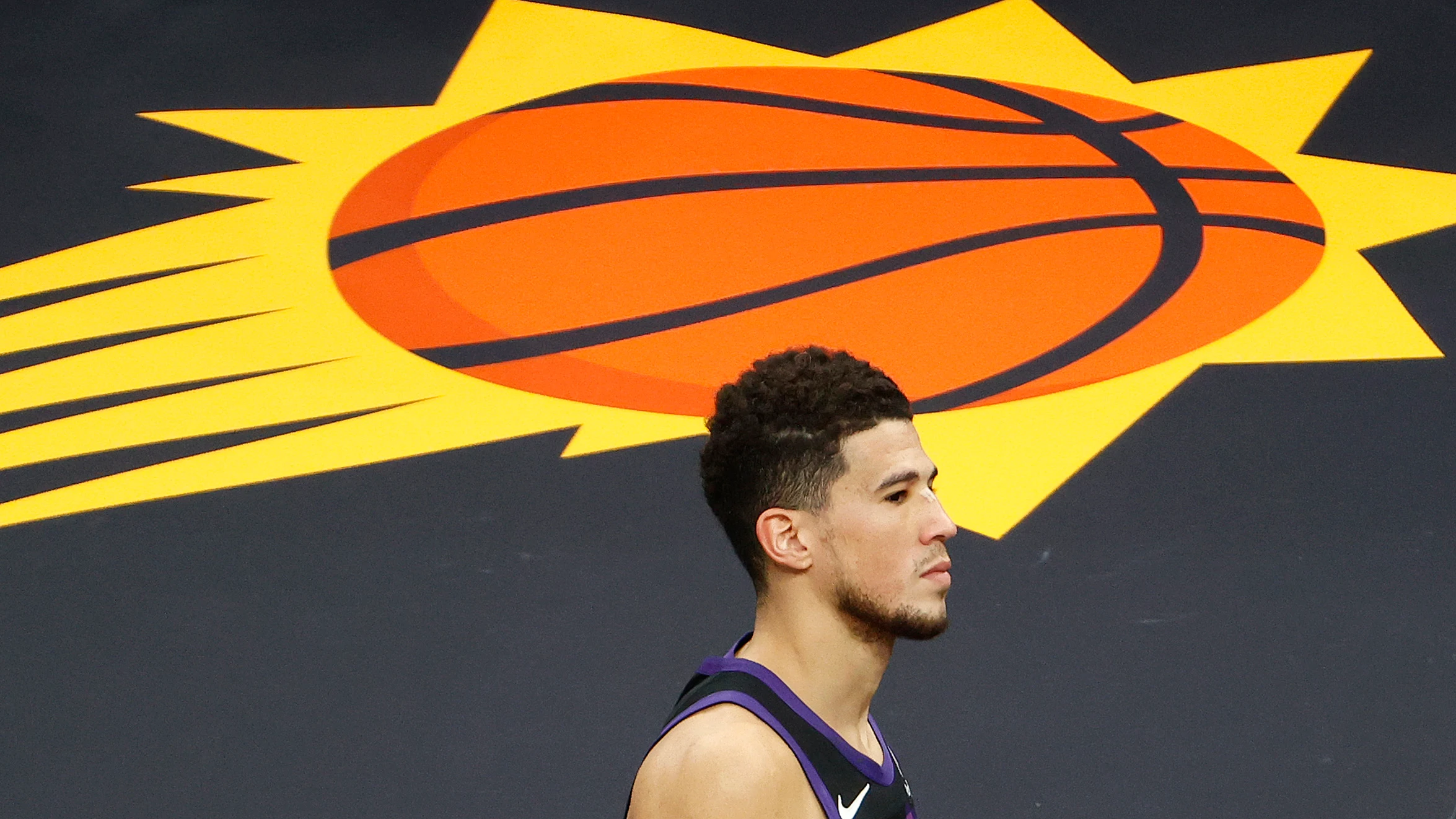 Devin Booker, con el logo de los Phoenix Suns de fondo