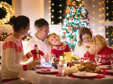 Una familia reunida en la mesa en Navidad Una familia reunida en la mesa en Navidad