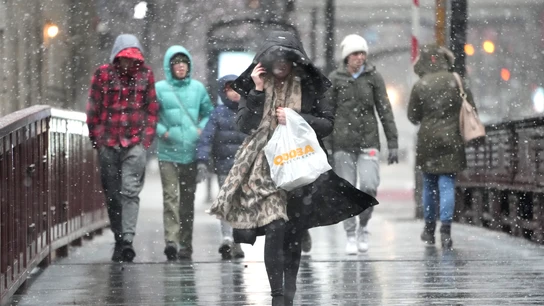 Los peatones cruzan el puente de Madison Street sobre el río Chicago cuando comienza una tormenta de invierno Los peatones cruzan el puente de Madison Street sobre el río Chicago cuando comienza una tormenta de invierno