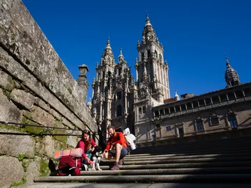 Dos peregrinos frente a la catedral de Santiago tras terminar el Camino de Santiago Dos peregrinos frente a la catedral de Santiago tras terminar el Camino de Santiago