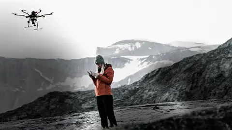 Joven volando un dron en una pista de esquí Joven volando un dron en una pista de esquí