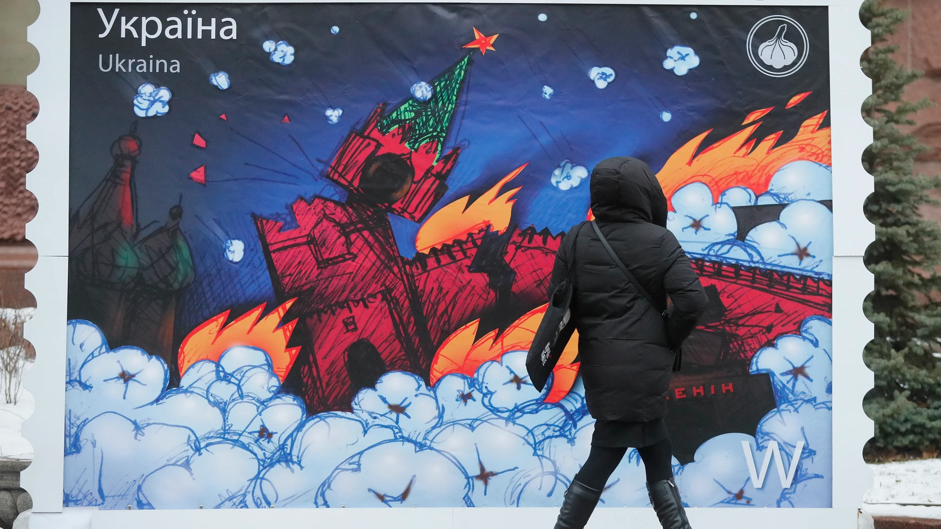 Una mujer observa un sello a gran escala que muestra al Kremlin en llamas, este lunes en Kyiv, Ucrania.