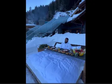 Hombre desayunando en una cama en la nieve Hombre desayunando en una cama en la nieve