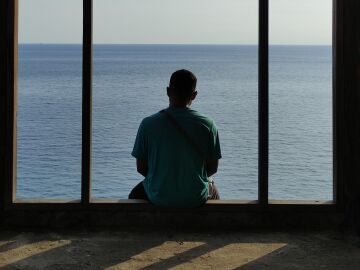 Joven sentado frente al mar