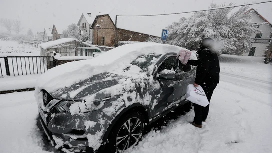 Una persona limpia su coche bajo la nieve en enero de 2023 Una persona limpia su coche bajo la nieve en enero de 2023
