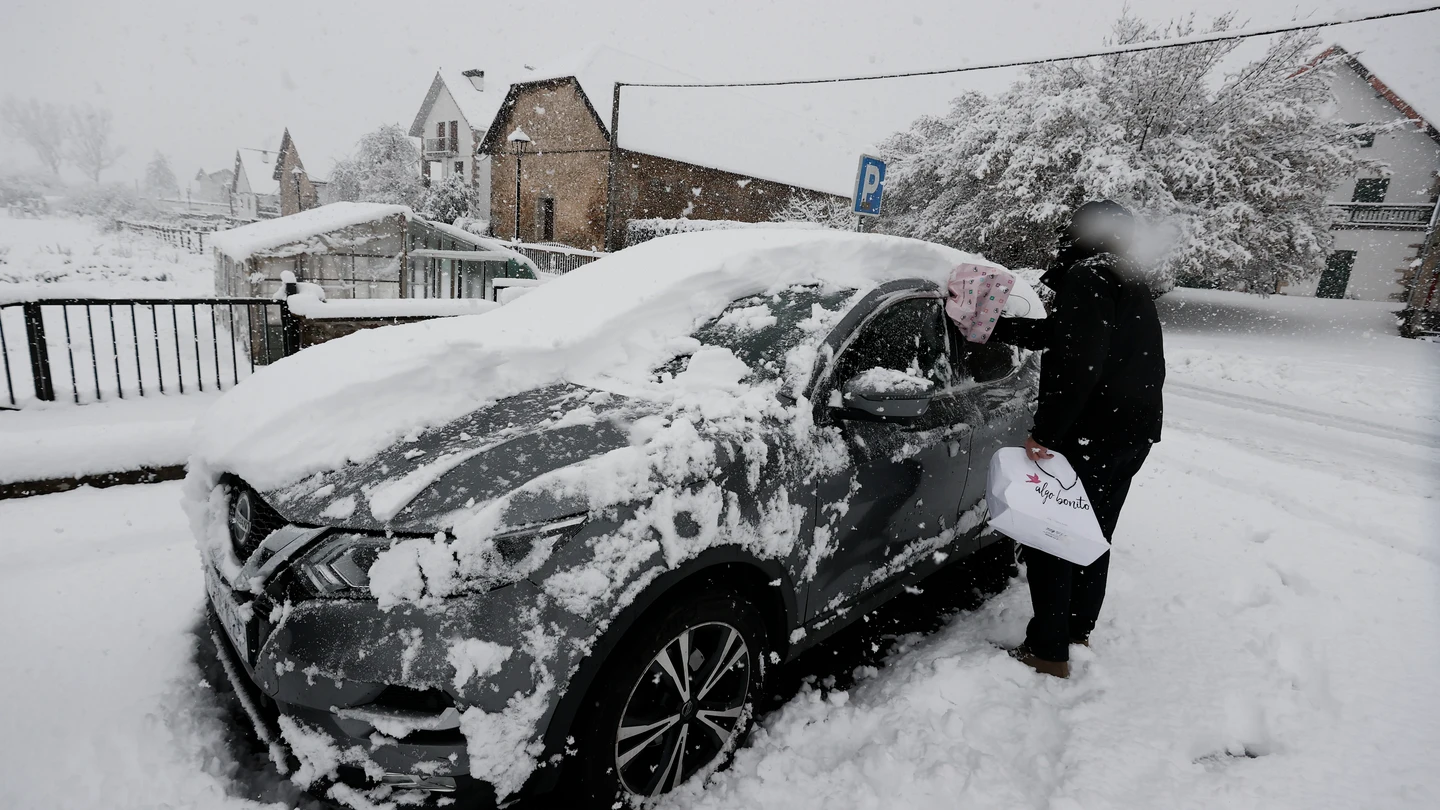 Una persona limpia su coche bajo la nieve en enero de 2023 Una persona limpia su coche bajo la nieve en enero de 2023